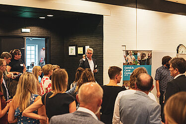 Link til større version af billede, hvor Michael E. Caspersen byder velkommen til postersession